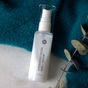 Image of a spritz bottle of Hydrating Facial Mist with a blue towel and a eucalyptus branch.